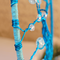 blue wire closeup as it is wrapped and secured to yarn covered hoop